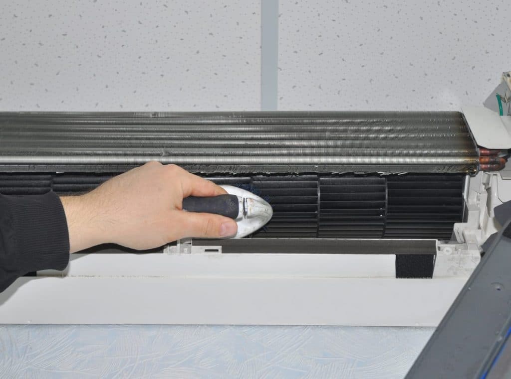 homeowner cleaning a ductless mini split