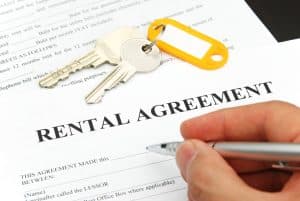 rental agreement form with signing hand and pen and keys