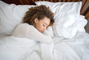 woman sleeping on bed inside a comfortable home