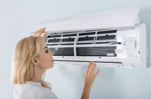 A San Diego homeowner checks her AC unit for potential problems during a hot summer month.