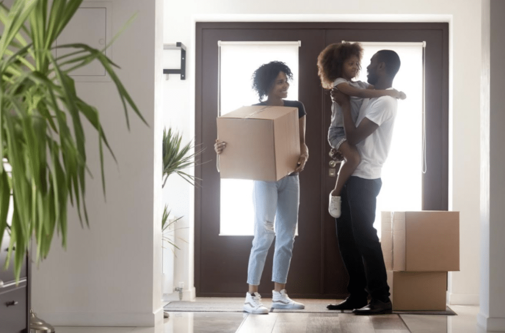 Family photo of a husband, wife and daughter moving in to their new home